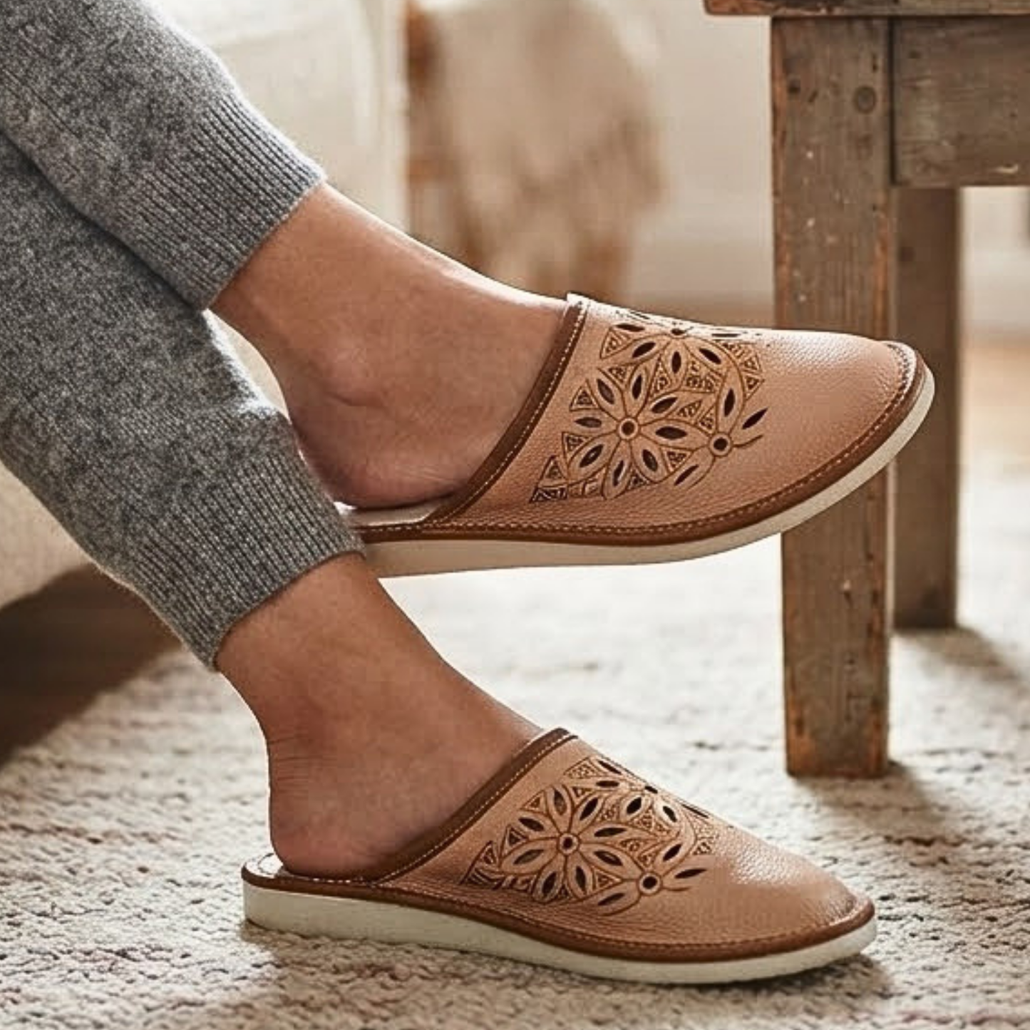Woman wearing beige genuine leather slippers with floral cutout design at home, cozy indoor house shoes