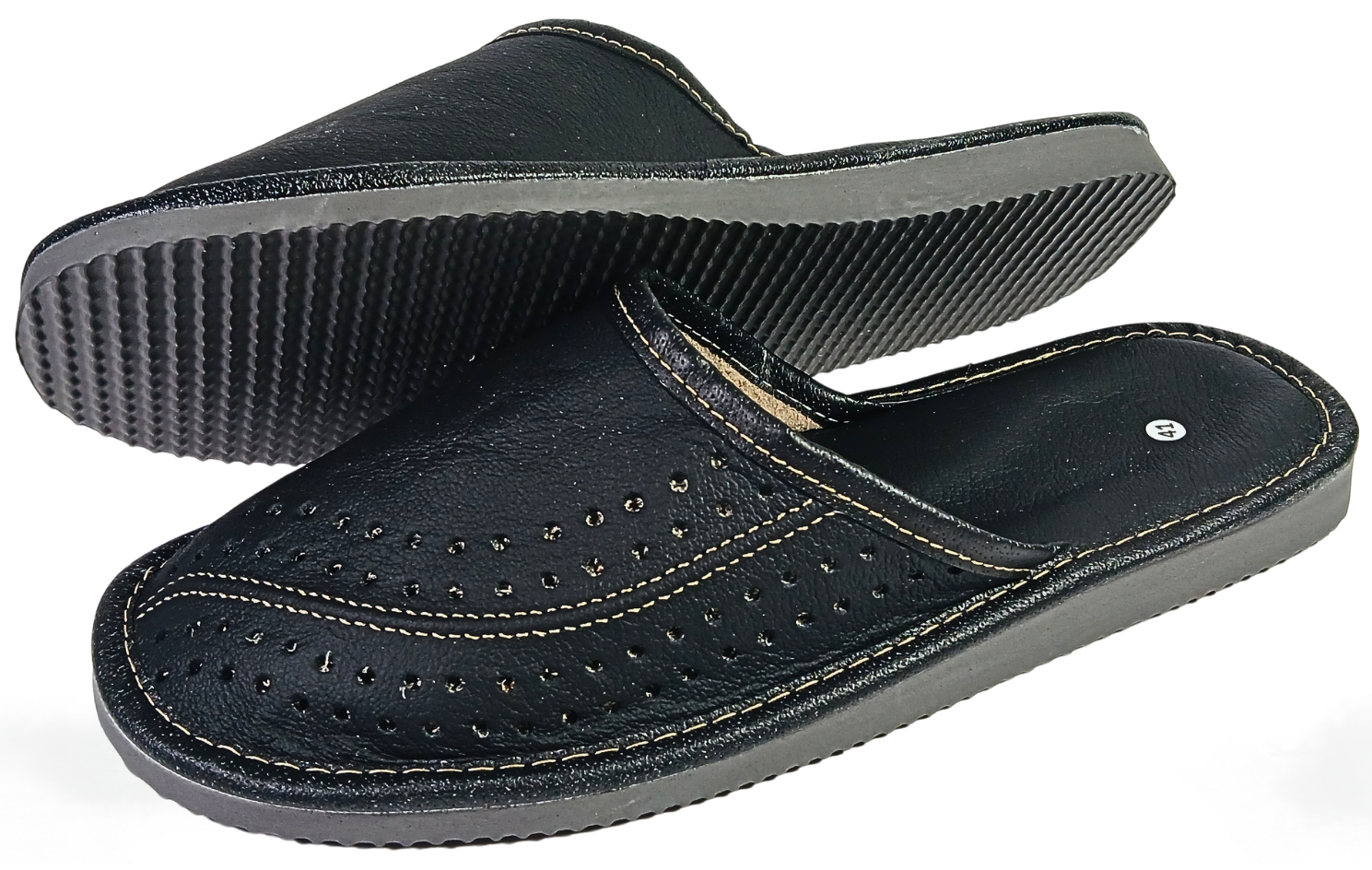 Pair of men's black buffalo leather closed-toe mule slippers showing perforated upper and grey ribbed rubber outsole from three-quarter angle — The Leather Gift Co